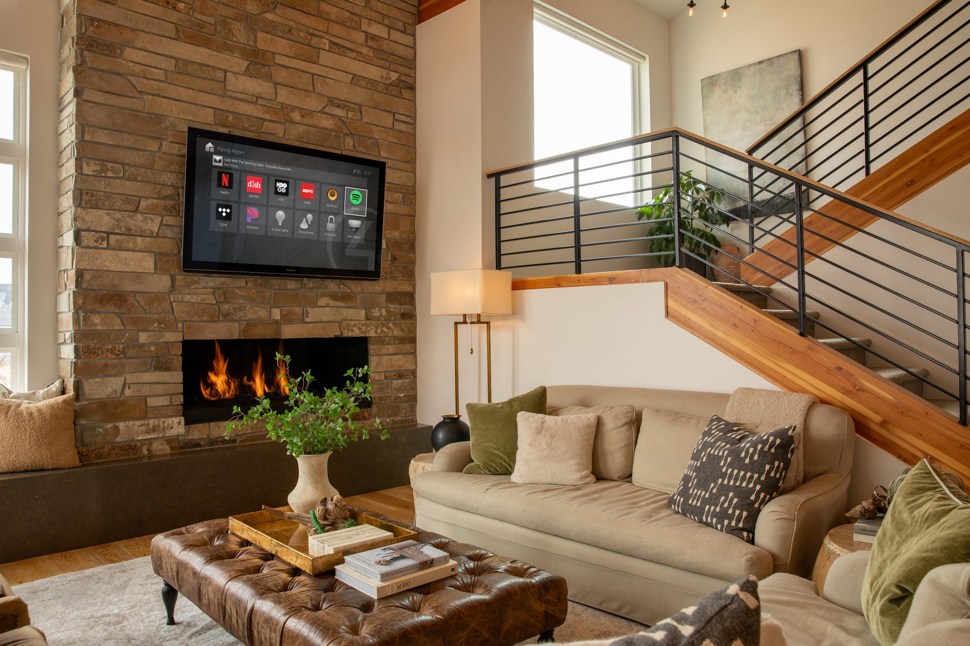 Living room with a stone fireplace and a TV showing the Control4 interface