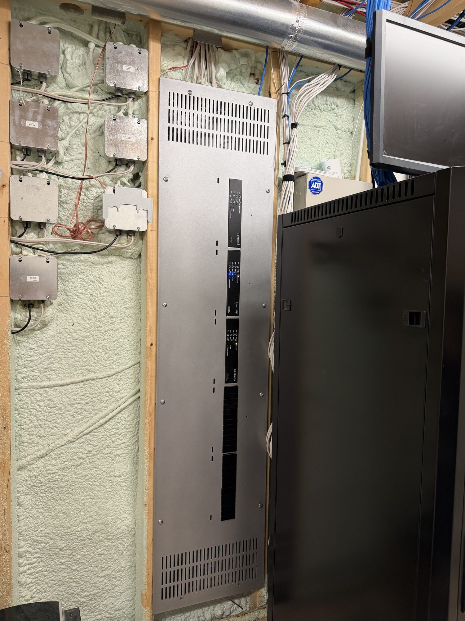 Control4 lighting panel installed in the wall next to the equipment rack